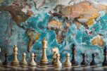 Chess pieces on world map background set of chess pieces on a wooden board against the backdrop of a colorful, aged world map, evoking themes of global strategy and power play