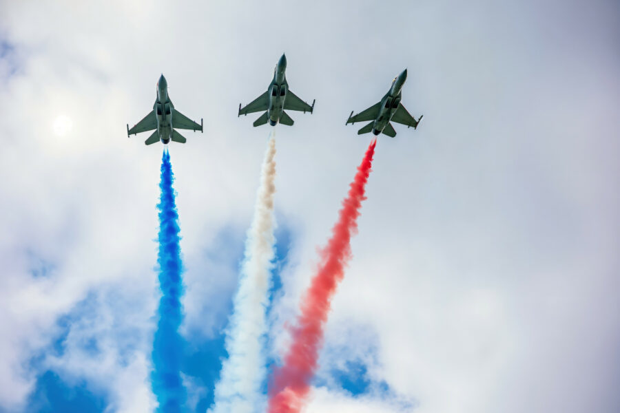 Three fighters in a harsh form, leaving red, white and blue smoke of the flag of france