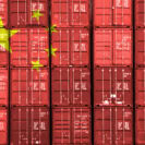 China flag over stack of containers at a port